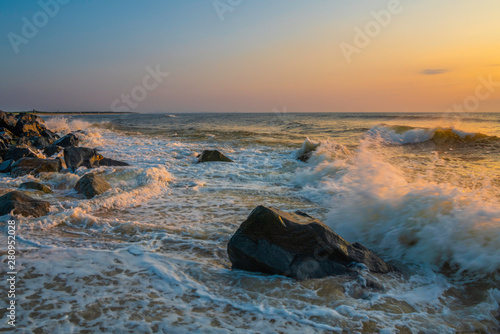 Peaceful sunrise over Sandy Hook beach, New Jersey featuring beautiful waves on the foreground