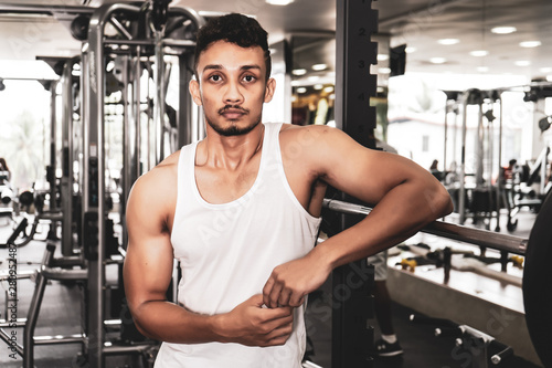 Fit man standing and relax after the training session in gym,Concept healthy and lifestyle,Male taking a break after exercise and workout