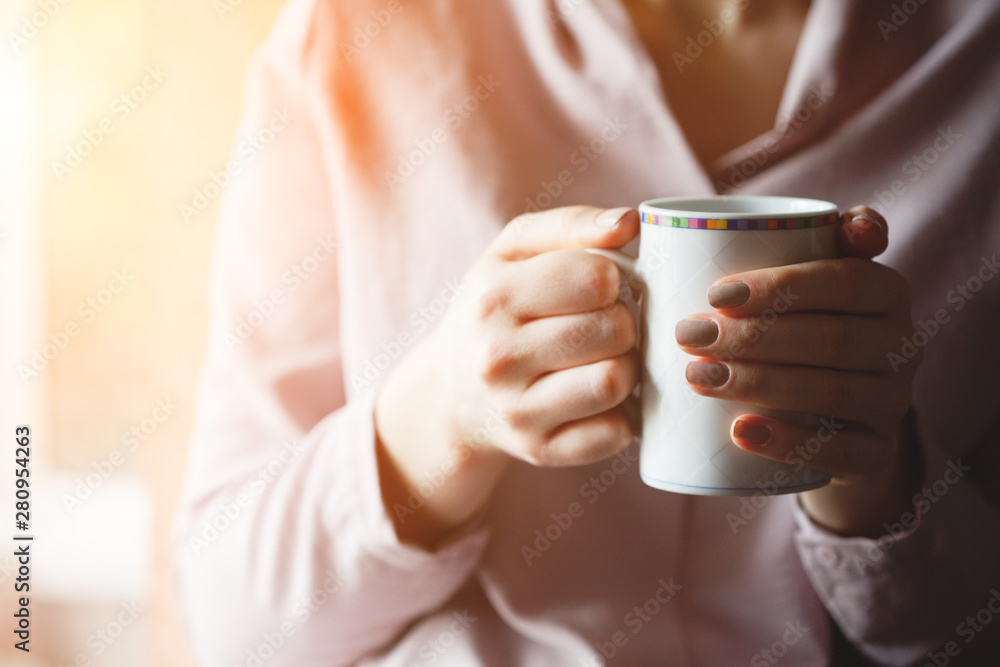 female hands holding cup of hot tea or coffee drink, sunny morning, copy space female hands holding cup of hot tea or coffee drink, sunny morning, copy space