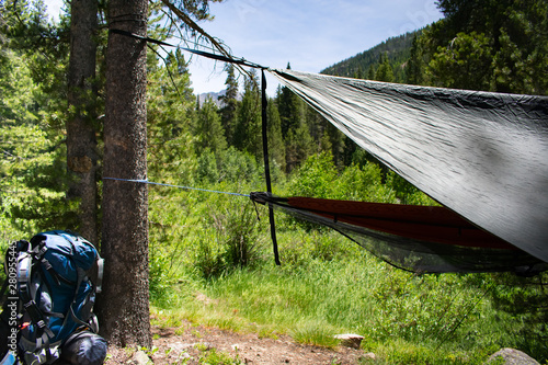 Hammocks hanging with backpack in foreground on a trail in Colorado Rocky Mountains