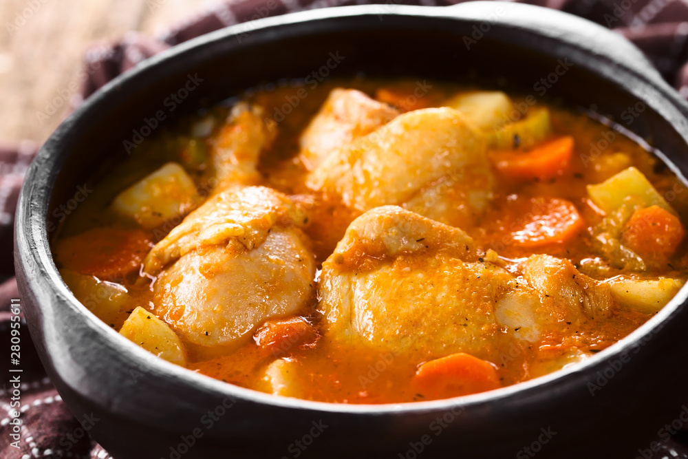 Fresh homemade chicken stew with potato, carrot and celery, seasoned with paprika in rustic bowl (Selective Focus, Focus one third into the image)