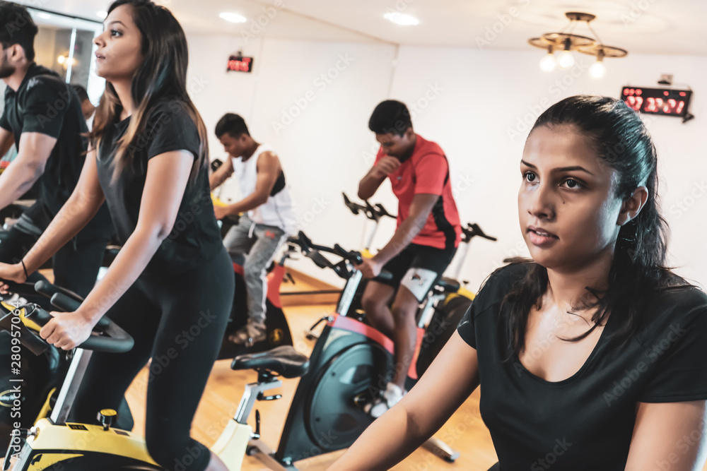 Fit people working out at spinning class in gym Fit people working out at spinning class in gym