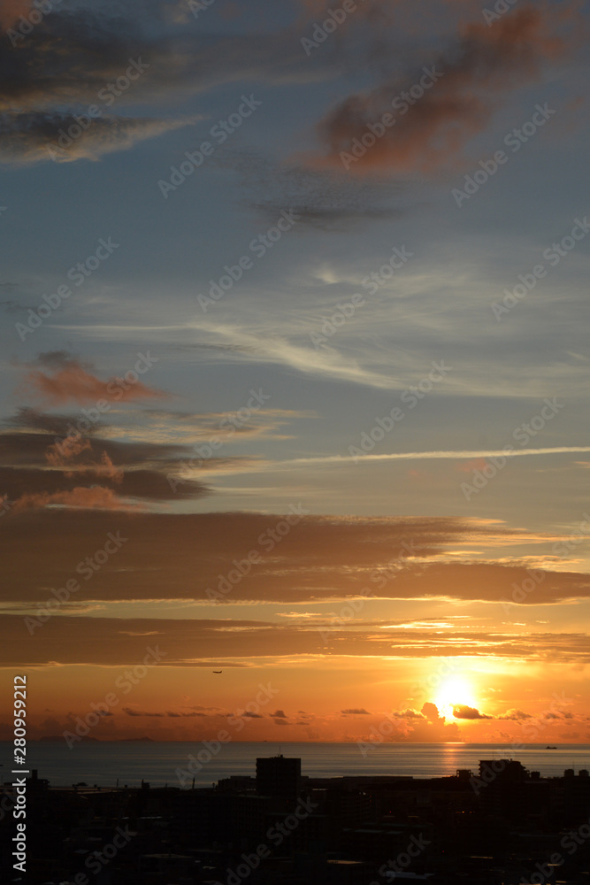 Fototapeta premium オレンジ色の夕日と都会のシルエット