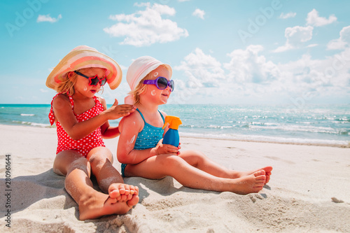 sun protection, cute girls with sun cream at beach