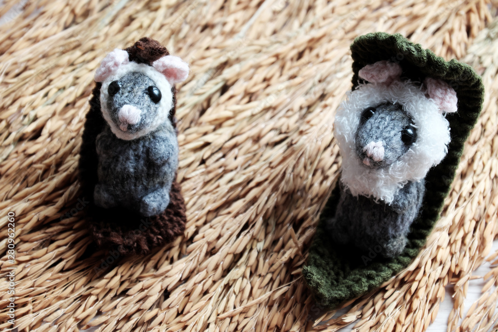 Fototapeta premium Cute mouse relax on sheaf of paddy, woolen small rat