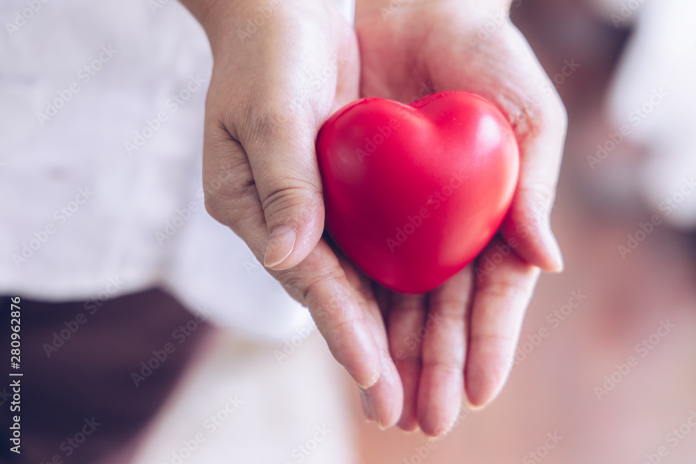 Elderly hand with wound carrying red heart. asian elderly woman holding red heart shape,