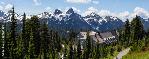 Beautiful Panoramic American Mountain Landscape view with a Chalet during a sunny summer day. Taken in Paradise, Mt Rainier National Park, Washington, United States of America.