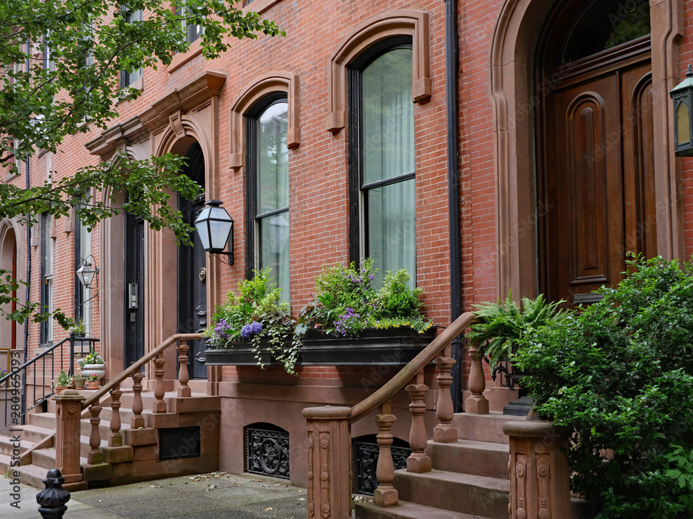 Elegant old brownstone townhouses with window box and stone steps and balustrade