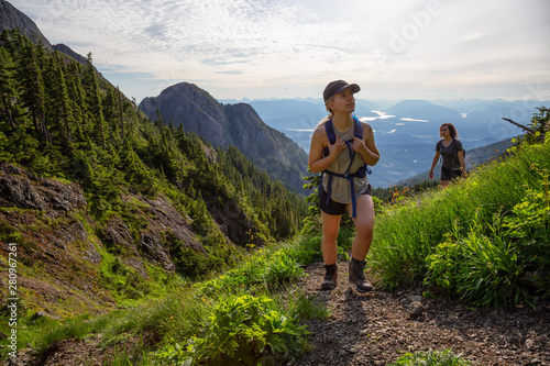 Adventurous girl hiking the beautiful trail in the Canadian Mountain Landscape during a vibrant summer evening. Taken at Mt Arrowsmith, near Nanaimo, Vancouver Island, BC, Canada. © edb3_16