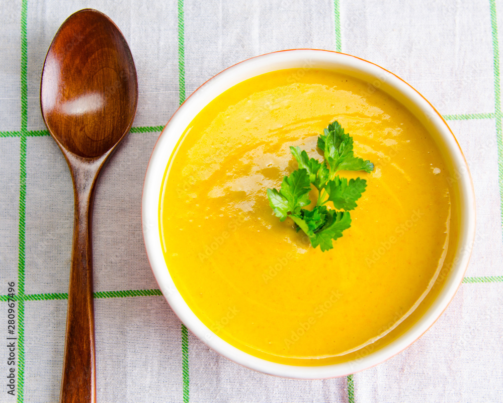 Carrot soup served on the table in bowl Carrot soup served on the table in bowl