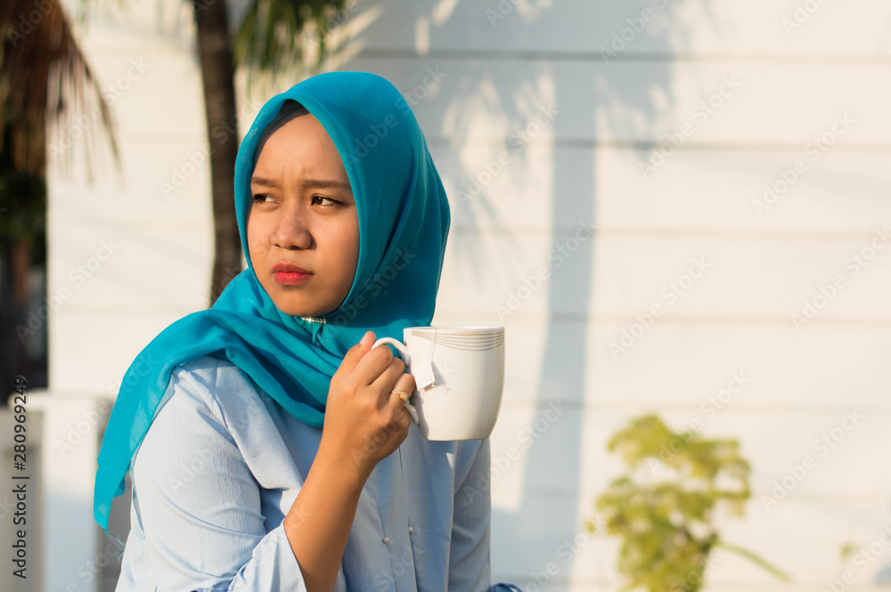 close up portrait of happy shot two hijab women drinking tea in front of the house and smiling close up portrait of happy shot two hijab women drinking tea in front of the house and smiling