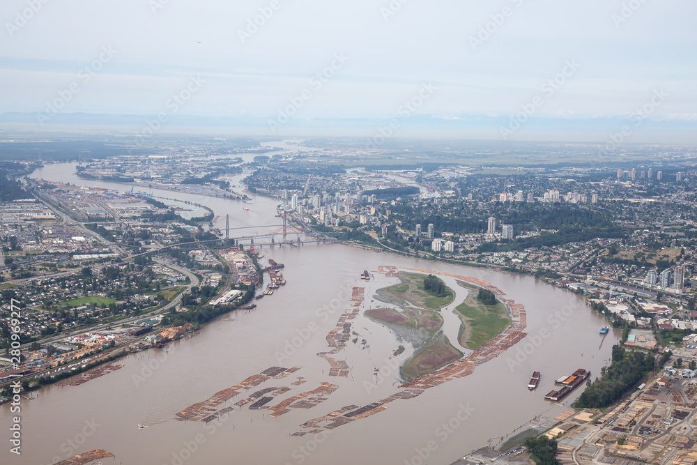 Aerial view of Industrial Sites in Fraser River during a misty summer day. Taken in New Westminster, Greater Vancouver, British Columbia, Canada.