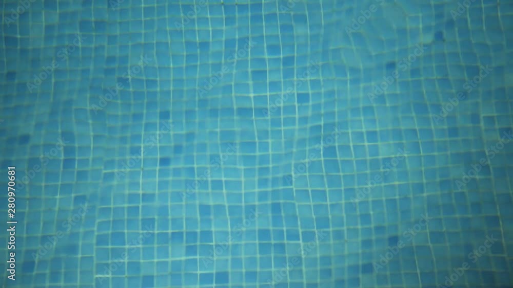 Looking down into a swimming pool at night at the refracted pool tiles ...
