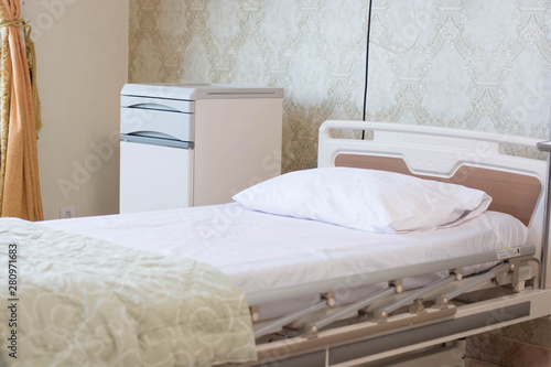 focused indoors empty hospital room with comfortable bed with pillow and electrical support at day light