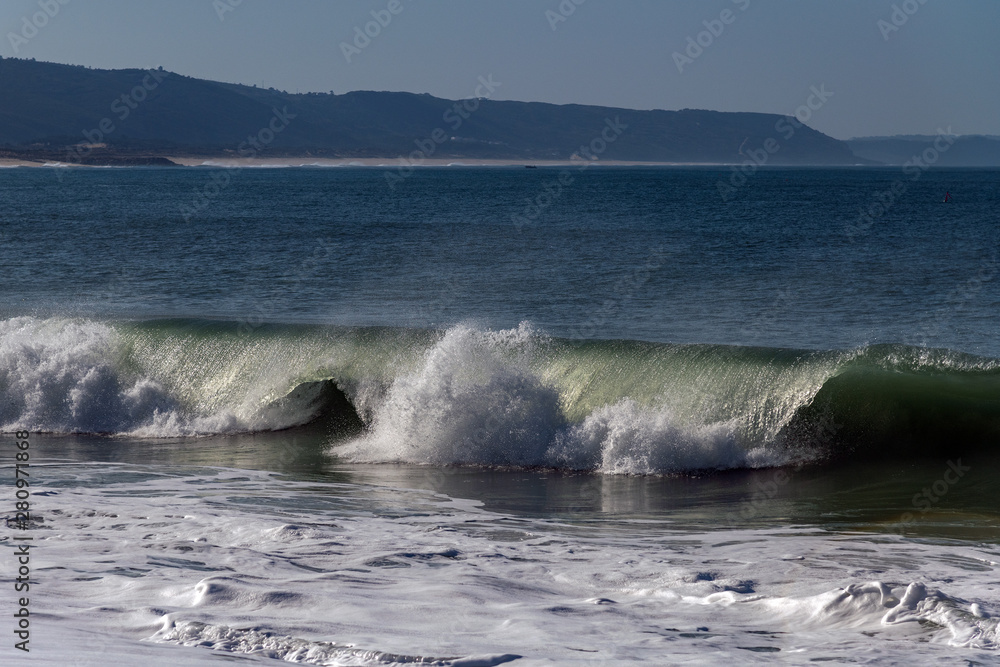 Naklejka premium Foamy Atlantic waves next to Nazare, Portugal.
