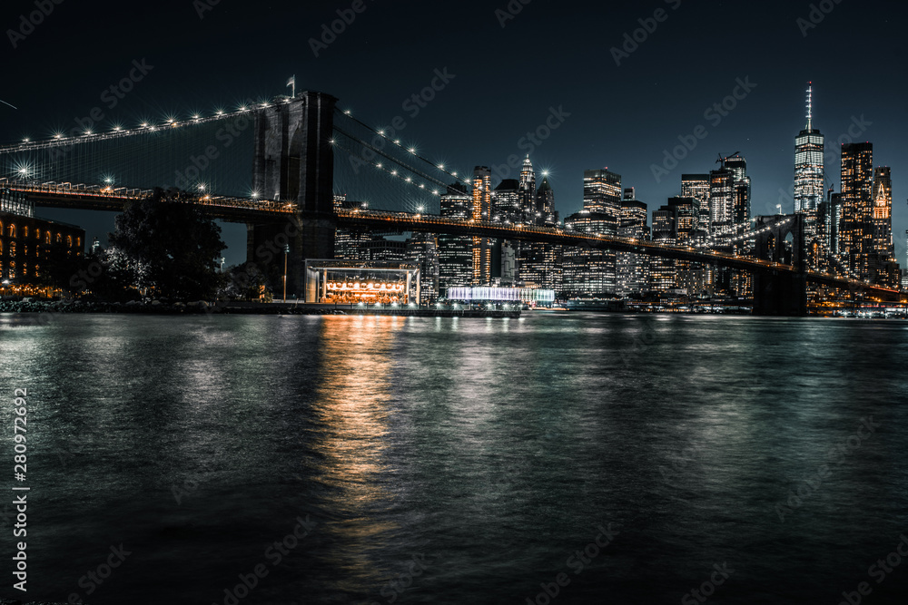 Waterfront Brooklyn with iconic Brooklyn Bridge and downtown Manhattan during the evening