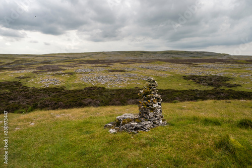 Moughton Scar is a vast and impressive limestone pavement full of interesting nooks and crannies. In the distance a moody Pen-y-ghent is seen in profile. photo