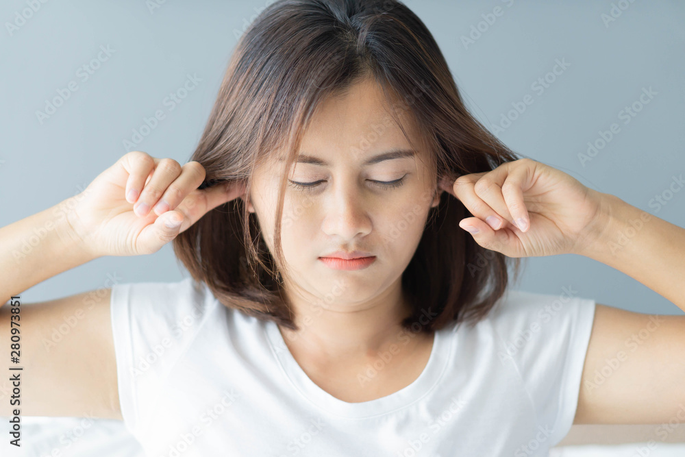 Closeup woman covering ears with her hand, noise problem, selective focus Closeup woman covering ears with her hand, noise problem, selective focus