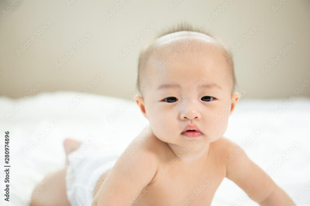 Asian baby happy in the room.Asian baby girl lying down on bed . Asian baby happy in the room.Asian baby girl lying down on bed .