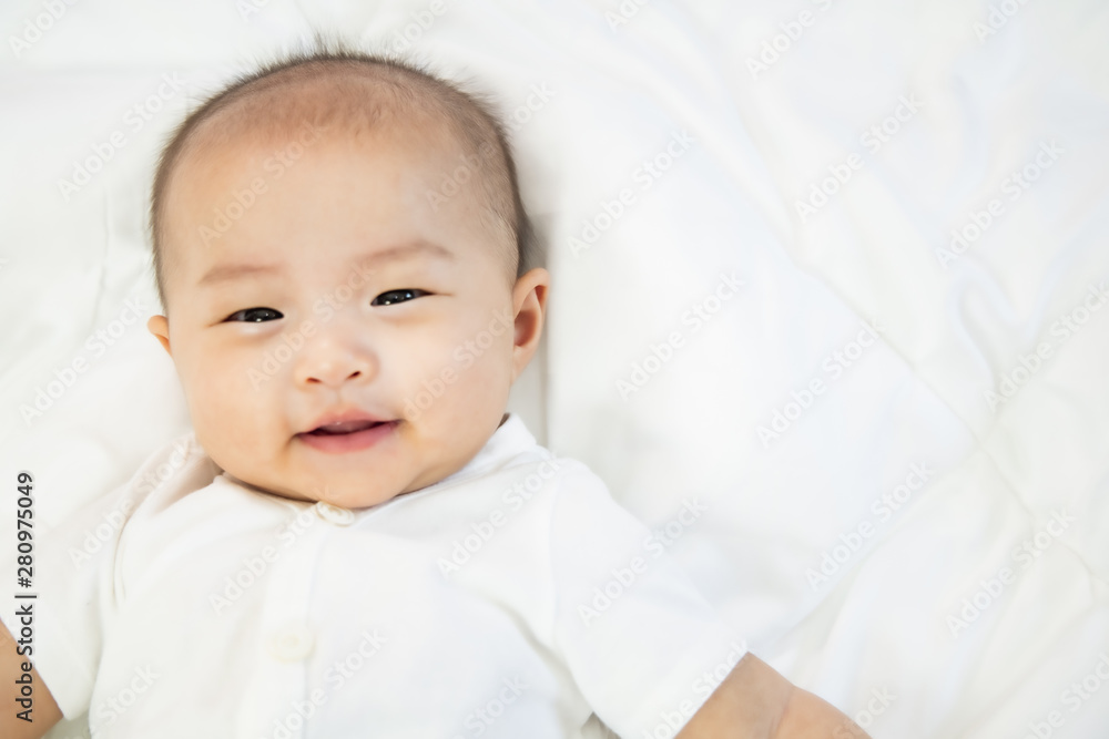 Asian baby happy in the room.Asian baby girl lying down on bed . Asian baby happy in the room.Asian baby girl lying down on bed .