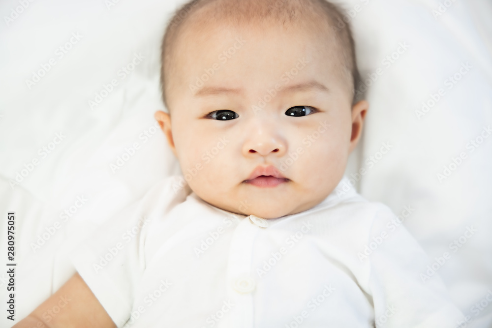 Asian baby happy in the room.Asian baby girl lying down on bed . Asian baby happy in the room.Asian baby girl lying down on bed .