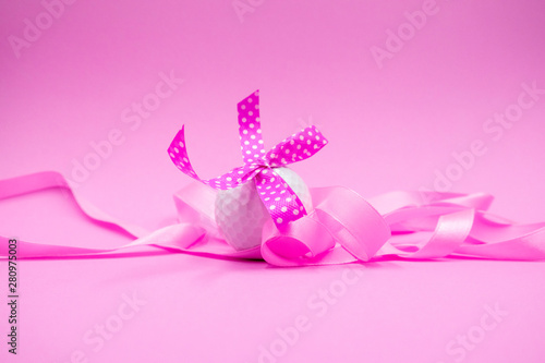 Golf ball with pink ribbon is on pink background © thaninee