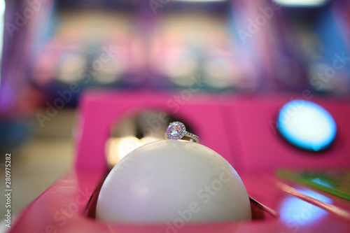 Engagement Ring Detail Shot on a Skee Ball in an Arcade photo