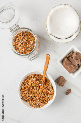 Overhead view of bowl with granola with coconuts and chocolate