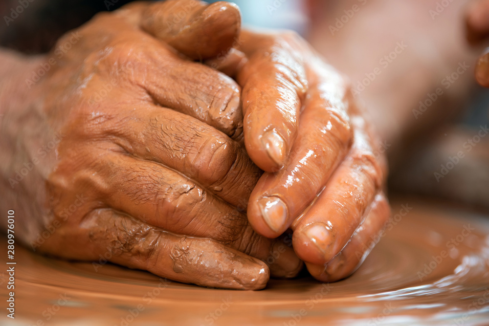 Potter makes pottery dishes on potter's wheel Potter makes pottery dishes on potter's wheel