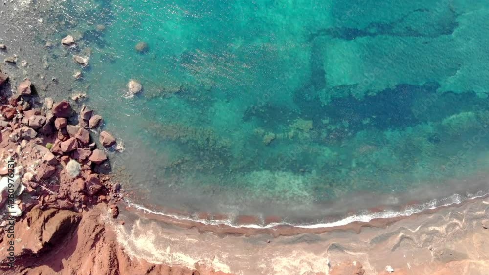 Flying over the red beach of Santorini, Greece with an amazing view of the ocean from above. Flying over the red beach of Santorini, Greece with an amazing view of the ocean from above.