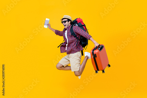 Happy Asian man with air ticket jumping