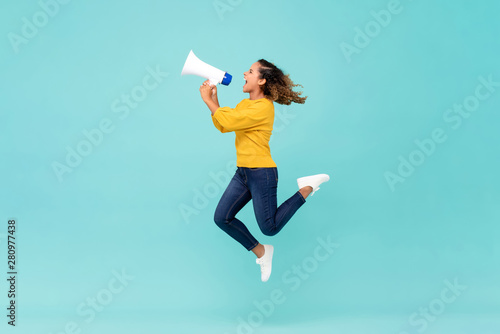 Girl with megaphone jumping and shouting photo