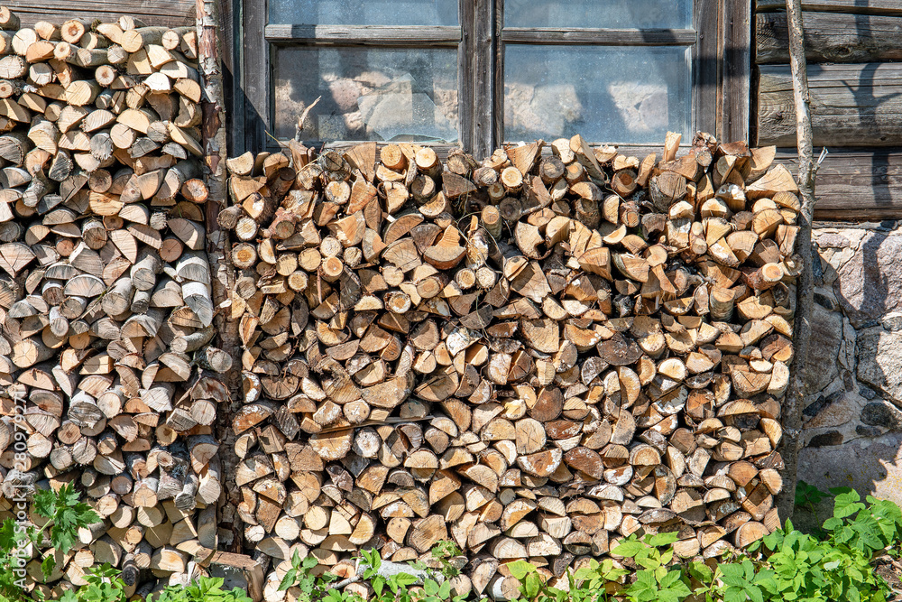 Background of dry chopped firewood logs in a pile. Preparation for the winter season, fossil fuels Background of dry chopped firewood logs in a pile. Preparation for the winter season, fossil fuels