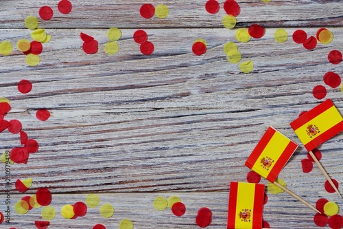 October 12. Independence day Spain concept of independence , patriotism and freedom. Mini paper flags with yellow red confetti on wooden background. hotizontal