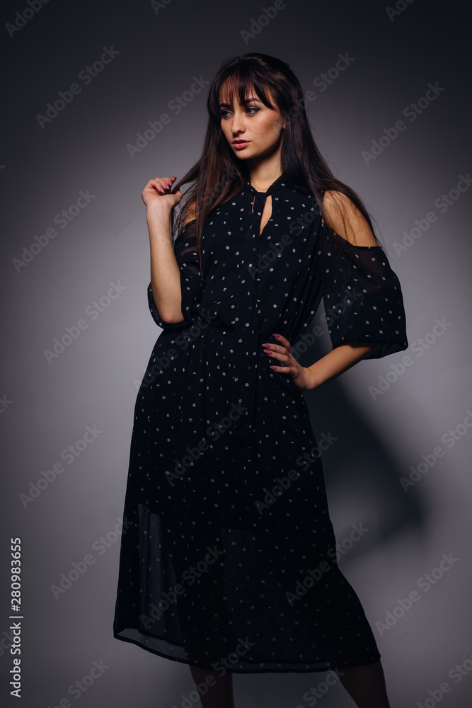 beautiful girl in a stylish blue polka dots dress poses on the b beautiful girl in a stylish blue polka dots dress poses on the b