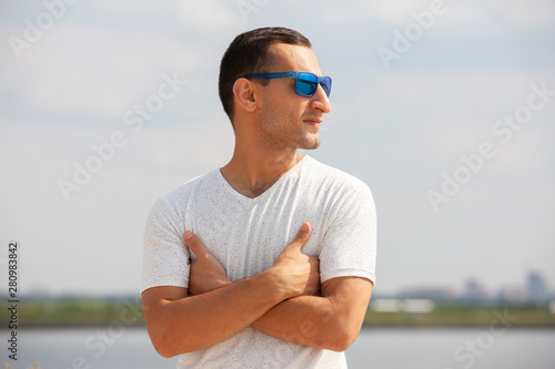 Smiling bearded young man showing thumbs up. Cheerful handsome young man gesturing outdoor.