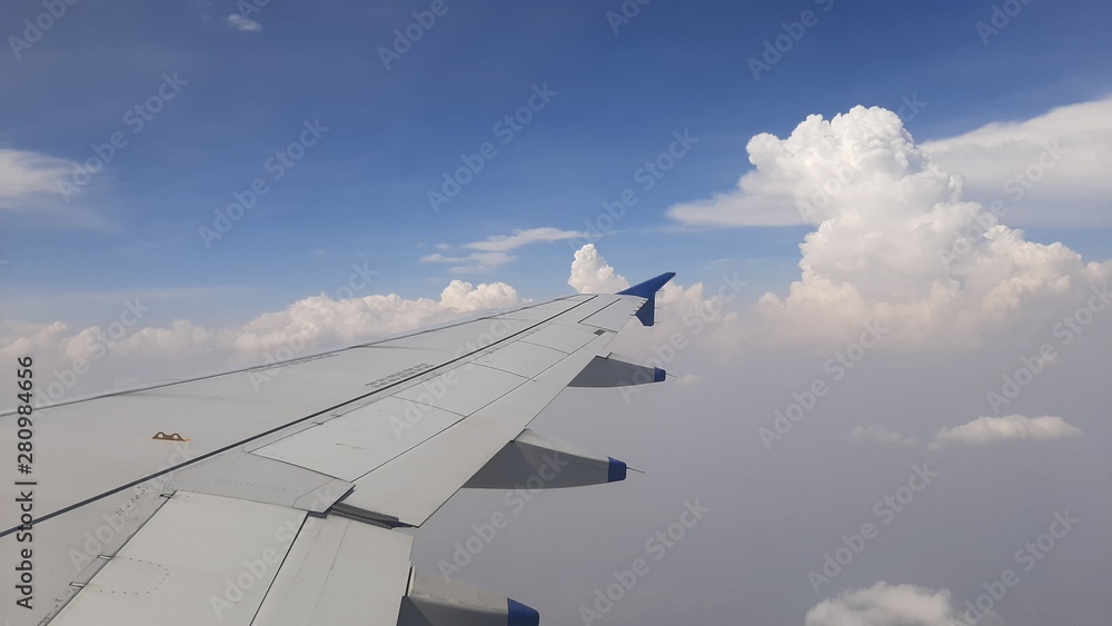 wing of airplane flying above clouds wing of airplane flying above clouds
