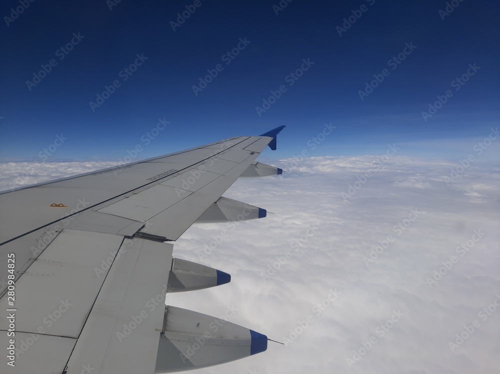 Fototapeta premium wing of an airplane flying above the clouds