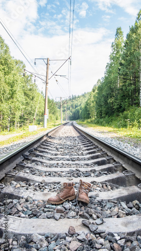 Old boots stand on the railroad. difficult road