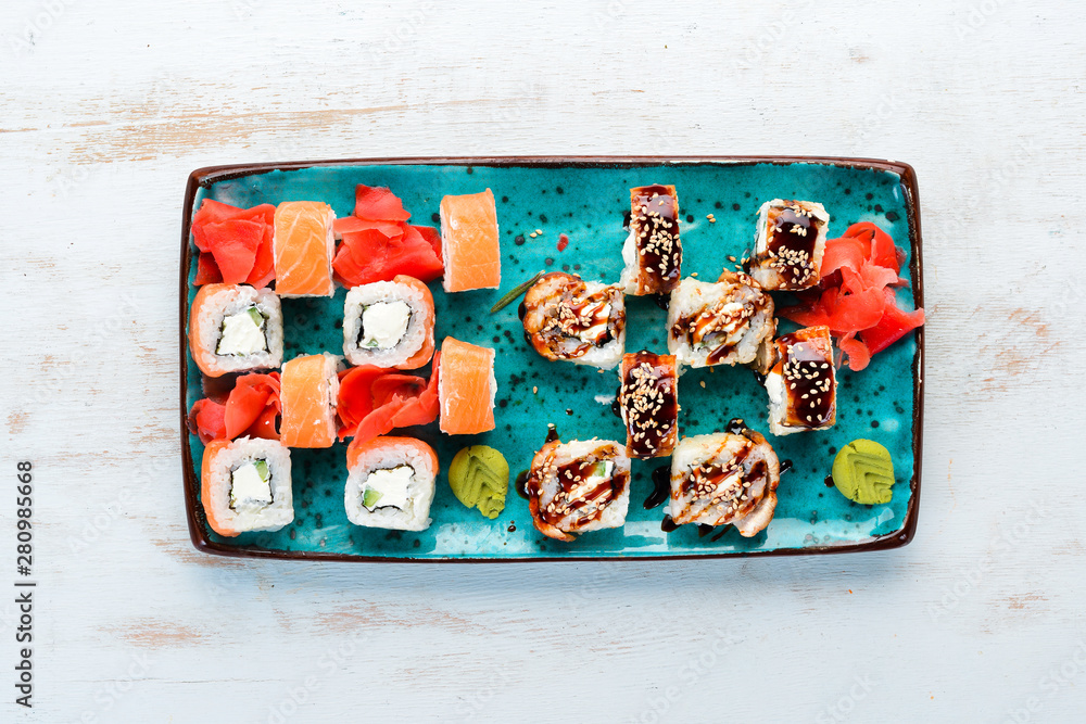 Sushi and maki rolls on a plate. Top view. Free space for your text. On a white background.