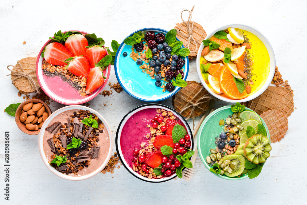 A healthy breakfast. Colorful fruit smoothies with yogurt, fresh fruit and berries. Top view. Free space for your text. On a white background. A healthy breakfast. Colorful fruit smoothies with yogurt, fresh fruit and berries. Top view. Free space for your text. On a white background.