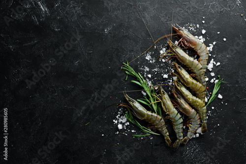 Raw black tiger prawns with lemon. Seafood. Top view. On a black background. Free copy space. photo