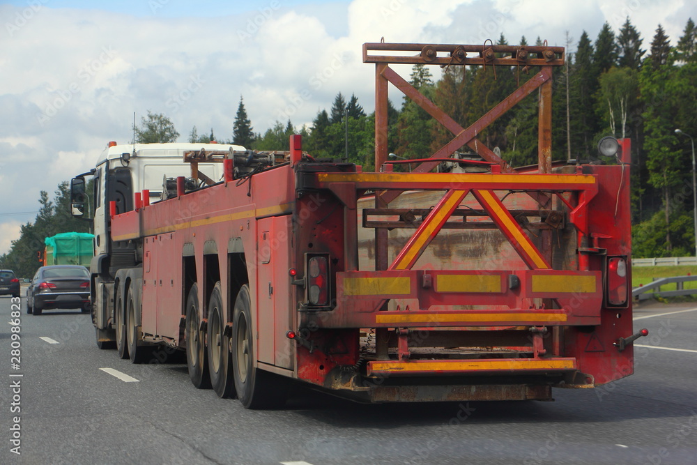 Heavy panel truck with semi-trailer rides on the highway on a summer day, logistics in the construction business Heavy panel truck with semi-trailer rides on the highway on a summer day, logistics in the construction business