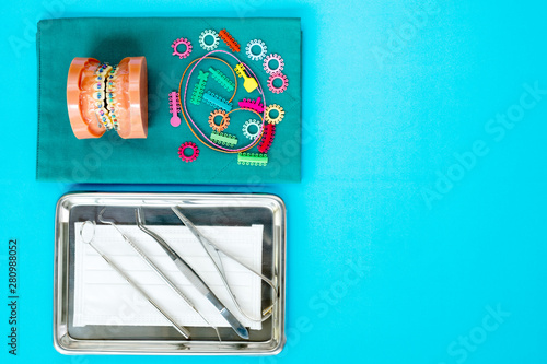 dentist tools and orthodontic model on the  blue background, flat lay, top view.