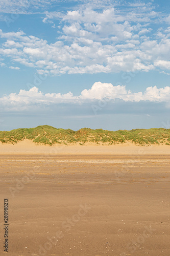 Looking back over the sandy beach towards the marram grass covered sand dunes, at Formby in Merseyside