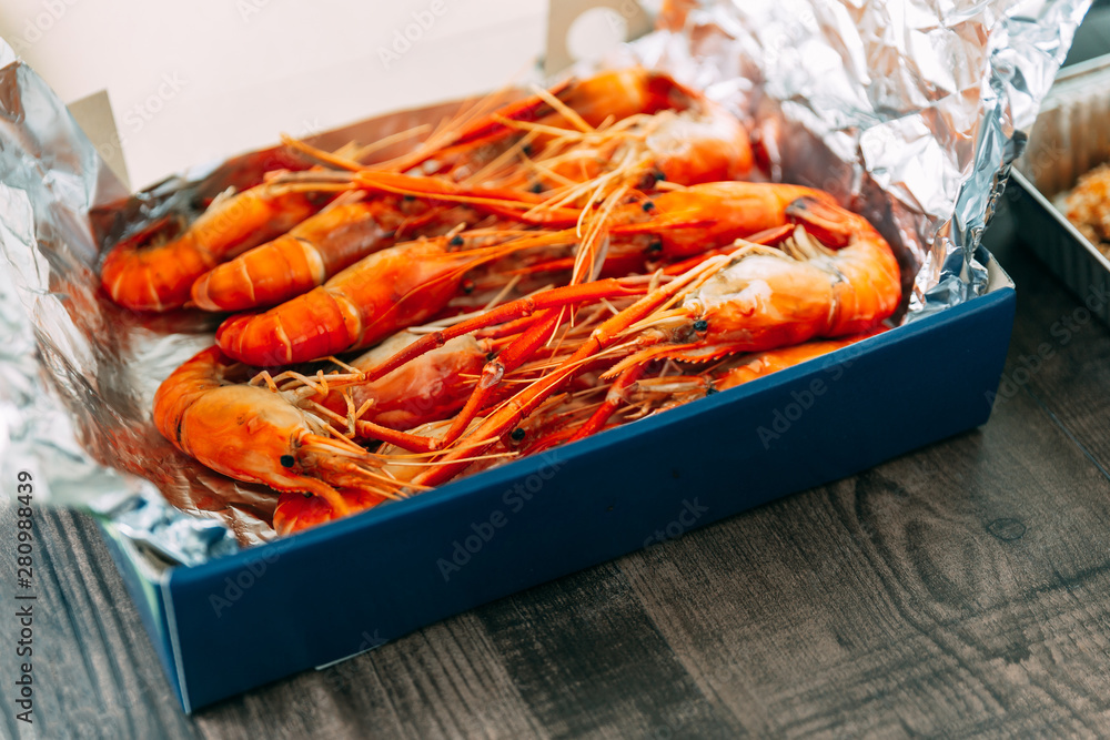 Top view of Thai grilled prawns (shrimps) in the shell in paper box that wrap with foil paper. Top view of Thai grilled prawns (shrimps) in the shell in paper box that wrap with foil paper.