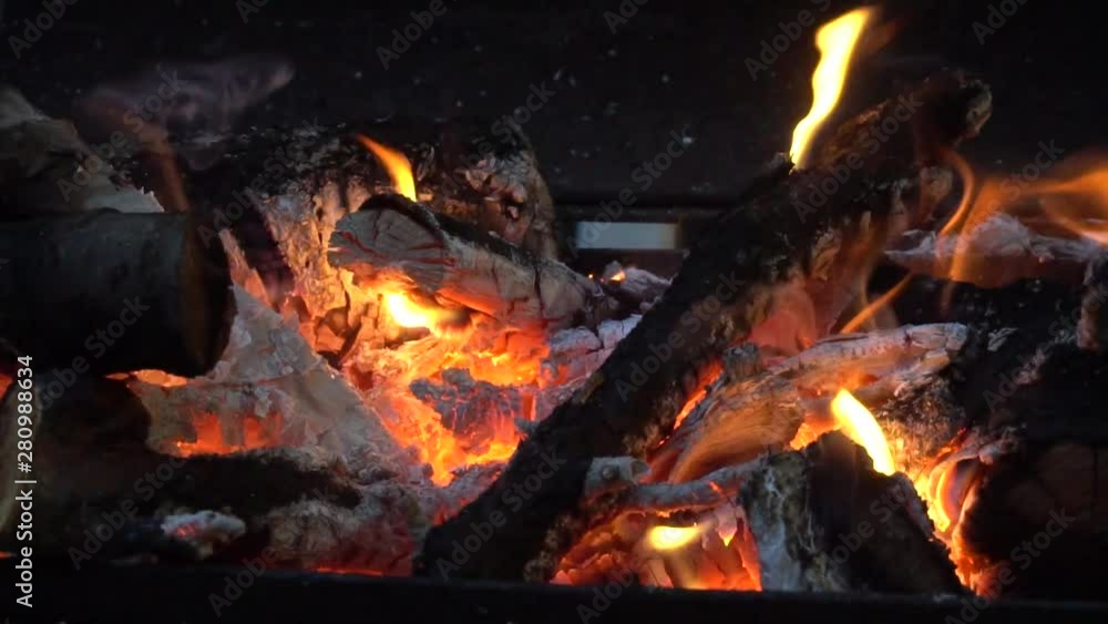 Bright fire flame from burning firewood from fruit trees on an open grill in the evening Bright fire flame from burning firewood from fruit trees on an open grill in the evening