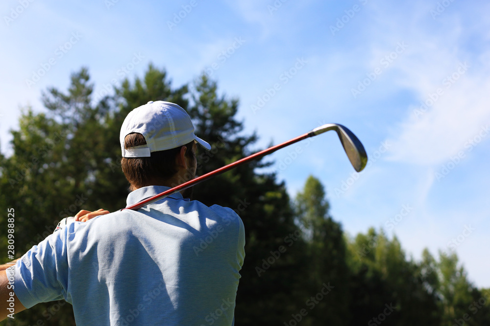 Athletic young man playing golf in golfclub.