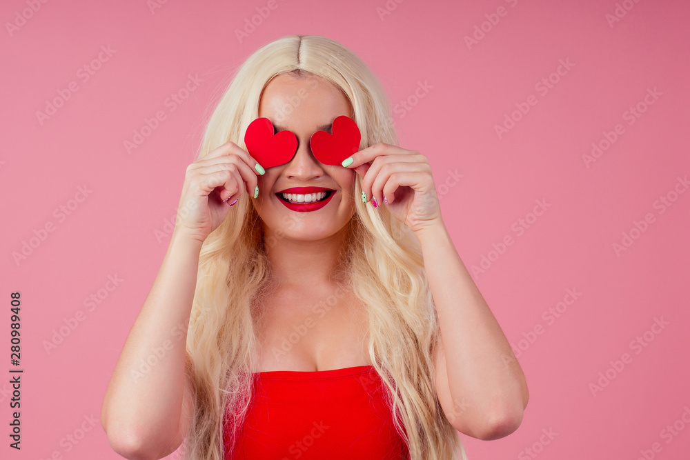 Closeup portrait of beautiful blond girl holding in hands paper heart isolated on pink background, Valentine day celebration Closeup portrait of beautiful blond girl holding in hands paper heart isolated on pink background, Valentine day celebration