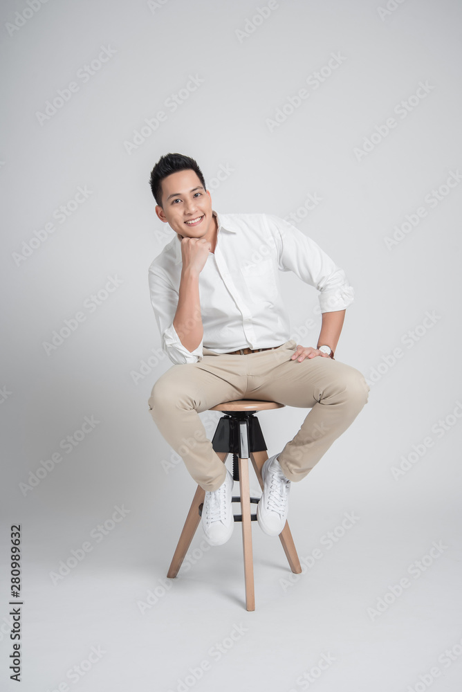 Happy confident Asian man relaxing while sitting on the chair Happy confident Asian man relaxing while sitting on the chair